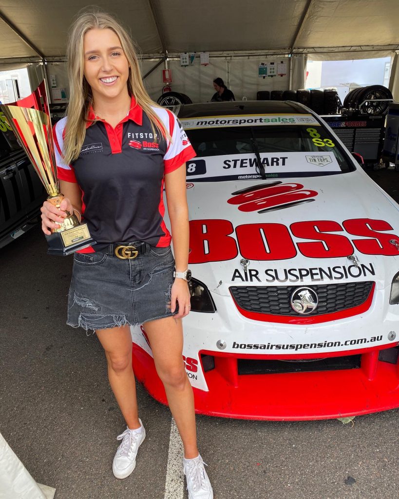 Lady holding Townsville Trophy in front of a Boss Air Suspension car